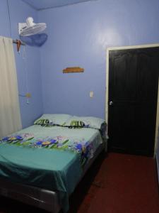 Habitación pequeña con cama y puerta negra en Hotel 24/7 en Comayagua