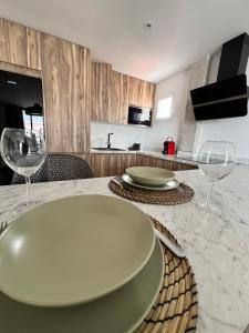 una cucina con tavolo con due piatti e bicchieri da vino di Alojamiento Joan Miro a Torremolinos