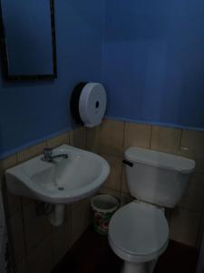 a bathroom with a white toilet and a sink at Hotel 24/7 in Comayagua