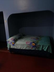 Una cama en un dormitorio con una colcha con flores. en Hotel 24/7 en Comayagua
