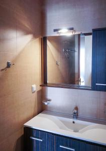 La salle de bains est pourvue d'un lavabo et d'un miroir. dans l'établissement Molivos Sunset Apartments, à Mithimna