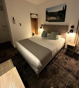 um quarto com uma cama grande num quarto em Logis Le Passiflore Cognac em Châteaubernard