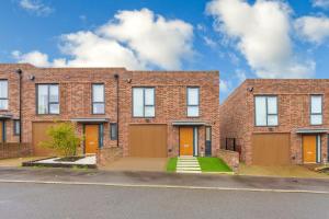 a brick building with orange doors on a street at 3 bedroom house in Bricket wood, St Alban in Garston