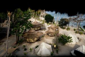 - une vue aérienne sur une plage avec des cabanes et des tentes dans l'établissement Dryft Darocotan Island, à El Nido