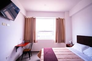 タクナにあるBruan Hotelのベッドルーム1室(ベッド1台、デスク、窓付)