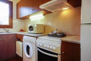 ミティムナにあるMolivos Sunset Apartmentsのキッチン(洗濯機、電子レンジ付)