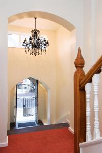 a hallway with a chandelier and a red carpet at St James House Serviced Apartments by Concept Apartments in London