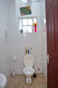 uma casa de banho branca com um WC e uma janela em Lesuki Breeze em Nairobi