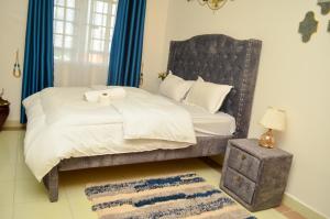 um quarto com uma cama grande e cortinas azuis em Lesuki Breeze em Nairobi