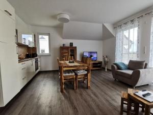 Holiday apartment Lotte Dree في Klein Kirr: مطبخ وغرفة معيشة مع طاولة وكراسي