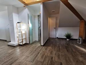 Holiday apartment Lotte Dree في Klein Kirr: غرفه فارغه ارضيه خشبيه وباب زجاجي