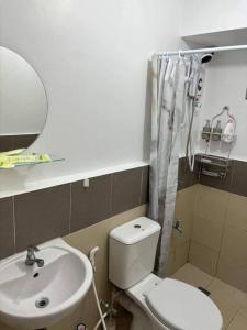 een badkamer met een wit toilet en een wastafel bij Hacienda Balai 9-2L in Manilla