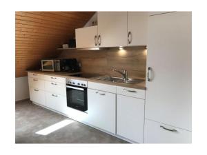 a kitchen with white cabinets and a sink at Haus Rieslehof Apartment 11 in Titisee-Neustadt