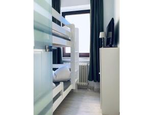 a bedroom with a bunk bed with a ladder at Sea air Modern retreat in Wangerooge