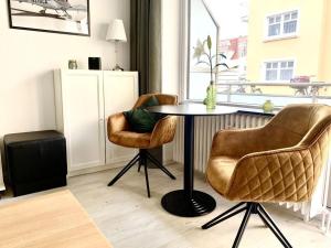 萬格羅格的住宿－Sea air Modern retreat，窗户间里的一张桌子和两把椅子