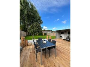 un patio con mesa y sillas en una terraza de madera en Friesenstuv Modern retreat, en Tönning