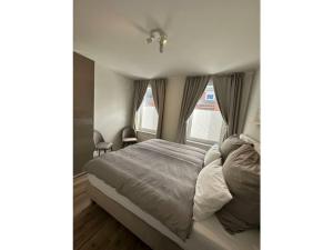 Un dormitorio con una cama y dos ventanas. en Friesenstuv Modern retreat, en Tönning