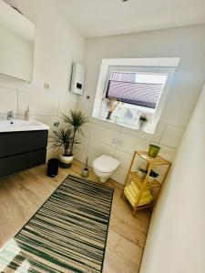 een badkamer met een wastafel, een toilet en een raam bij Studio Reichenstrasse in Quedlinburg