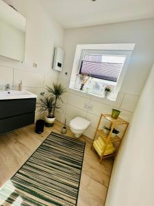 a bathroom with a sink and a toilet and a window at Studio Reichenstrasse in Quedlinburg +48 photos