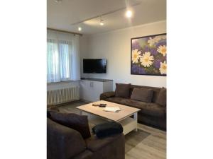 ein Wohnzimmer mit einem Sofa und einem Tisch in der Unterkunft Huis Hochfirst Appartement 10 in Titisee-Neustadt