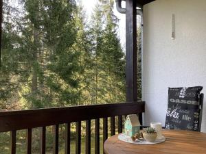 una mesa en un porche con vistas a un árbol en Huis Hochfirst Appartement 10, en Titisee-Neustadt