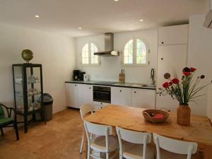 een keuken met een houten tafel en witte kasten bij Prat-Bourdin no 18 Hameau des Claudins in Le Revest-les-Eaux