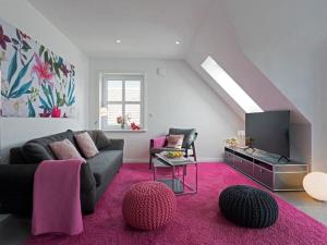 uma sala de estar com um sofá e uma televisão em Wild Duck Modern Retreat em Greetsiel