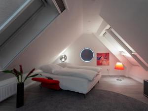 um quarto com uma cama branca e um banco vermelho em Wild Duck Modern Retreat em Greetsiel
