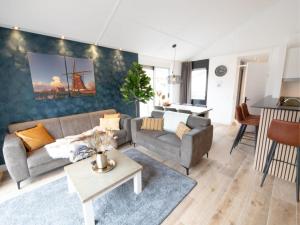 uma sala de estar com um sofá e uma mesa em Wellness Bungalow with whirlpool and sauna em Zevenhuizen