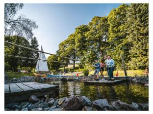 zwei Menschen stehen auf einer Brücke über einen Fluss mit einem Segelboot in der Unterkunft Huis Rieslehof Appartement 12 in Titisee-Neustadt