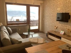 ein Wohnzimmer mit Sofa und Ziegelwand in der Unterkunft Vakantieappartement Evi in Lenzkirch