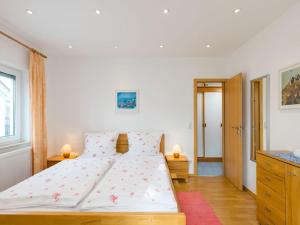a bedroom with a large white bed with flowers on it at Walnut Modern retreat in Hödingen