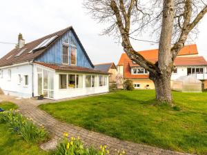 a white house with a tree in the yard at Walnut Modern retreat in Hödingen