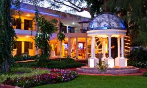 un bâtiment avec un kiosque dans un jardin dans l'établissement Hotel Ronda Minerva, à Guadalajara