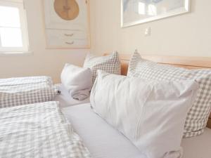Una cama blanca con almohadas blancas encima. en 14 Böhler Brise Modern retreat, en Sankt Peter-Ording