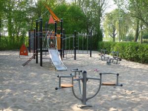 een speeltuin in een park met een glijbaan bij Wellness Bungalow with whirlpool and sauna in Zevenhuizen