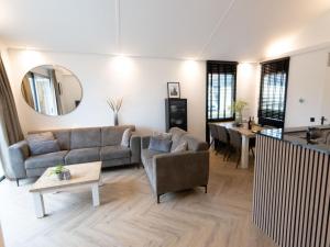 een woonkamer met een bank en een tafel bij Wellness Bungalow with whirlpool and sauna in Zevenhuizen