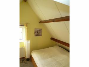 een kleine kamer met een bed op zolder bij Huijsmansverhuur Type A de Luxe Grevelingen 16 