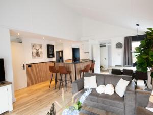 uma sala de estar com um sofá e uma cozinha em Wellness Bungalow with whirlpool and sauna em Zevenhuizen