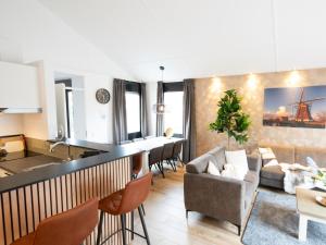 uma cozinha e sala de estar com um sofá e uma mesa em Wellness Bungalow with whirlpool and sauna em Zevenhuizen