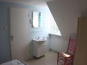 bagno con lavandino e sedia rossa di Manor House Rental Type A de Luxe Grevelingen 90 a Ouddorp Altre 32 foto