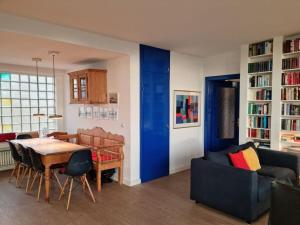 a living room with a table and a blue door at The Blue House Modern retreat in Wangerooge +19 photos