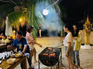 een groep mensen die rond een grill staan bij Amor Resort Koh Rong in Koh Rong Island