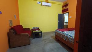 een slaapkamer met een bed, een stoel en een tafel bij Shail guest house in Ayodhya