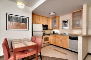 a kitchen with a small table and a refrigerator at Residence Inn Jackson in Jackson