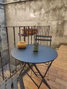 einem blauen Tisch auf dem Balkon in der Unterkunft Très grand et bel appartement in Nîmes