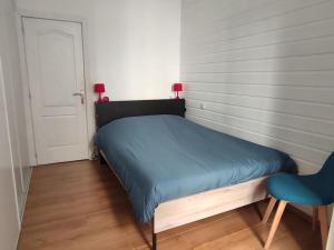 ein kleines Schlafzimmer mit einem blauen Bett und einem Stuhl in der Unterkunft Très grand et bel appartement in Nîmes