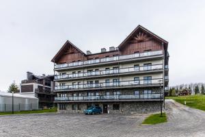 クルシュコフツェにあるApartament VELO Czorsztynの青い車が前に駐車されている建物