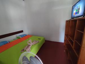 - une chambre avec un lit, une télévision et un ventilateur dans l'établissement Mí oficina, à Puerto Ayora