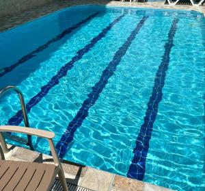 a blue swimming pool with a chair in it at Pamukkale Sahin Boutique Hotel in Pamukkale